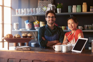 Portrait Of Couple Running Coffee Shop Behind Counter