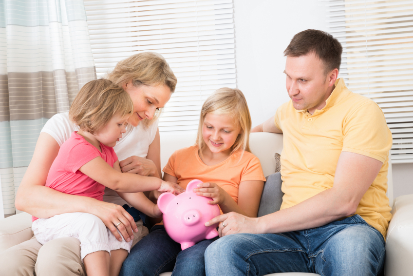 Family Saving Money In Piggybank